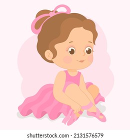 little ballerina in pink tutu sits on the floor, putting on pointe shoes and tying ribbons.