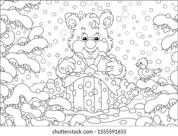 Little bear with a Christmas gift under snow-covered fir branches in a winter forest on a beautiful snowy day, black and white vector illustration in a cartoon style