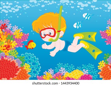 Little boy diving with a mask and a snorkel among funny striped fishes on a colorful coral reef in blue water of a tropical sea, vector illustration in a cartoon style