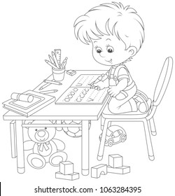 Little boy doing his homework in an exercise book with samples of writing, a black and white vector illustration in a cartoon style for a coloring book