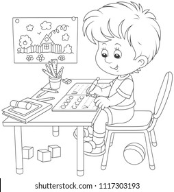 Little boy doing his homework in an exercise book with samples of writing, black and white vector illustration in a cartoon style for a coloring book