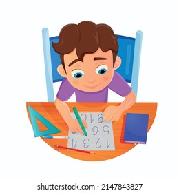Little boy doing homework by reading and writing numbers on his desk.