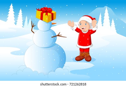 Little boy dressed in Santa Claus playing with snowman with winter background