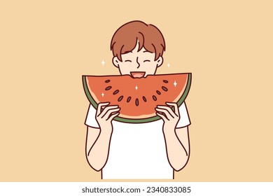 Little boy eats watermelon and smiles enjoying taste of juicy fruit that allows to refresh in hot summer weather. Happy child bites piece watermelon containing useful vitamins and substances