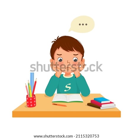 little boy feeling tired, bored and lazy studying doing his homework at the desk at home