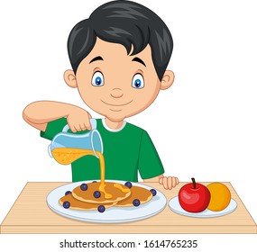 Little boy flowing maple syrup on pancakes with blueberries