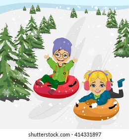 little boy and girl sliding down hill on tubes