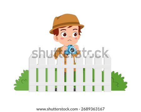 Little Boy with Hat Taking Photo Behind Fence with Camera Looking Sad Wearing Jacket
