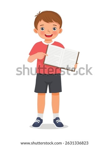 Little boy holding showing open book pointing at book page standing