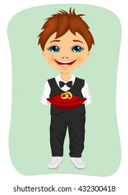 Little boy holding wedding rings on cushion. Ring bearer