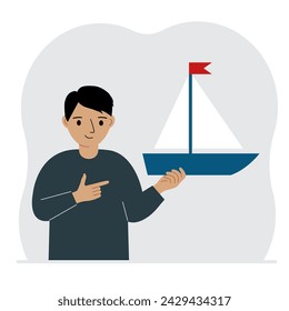 A little boy holds a sailing yacht in his hand. Concepts of freedom, hope and big plans. Hobby.