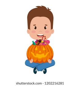 little boy lifting halloween pumpkin with candies