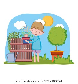 little boy lifting houseplant with fence and tree