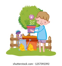 little boy lifting houseplant with fence and chick