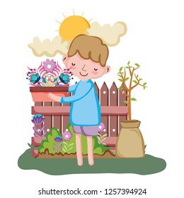 little boy lifting houseplant with fence in the garden