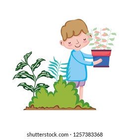 little boy lifting houseplant in the garden