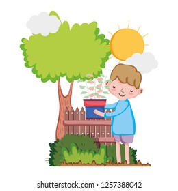 little boy lifting houseplant with tree and fence
