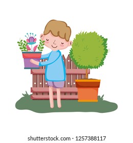 little boy lifting houseplant with tree and fence
