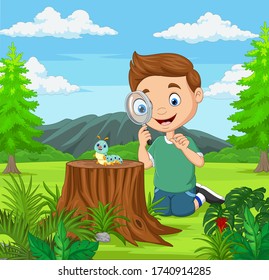 Little boy looking at caterpillar using magnifier in the garden