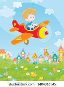 Little boy piloting his small toy plane among white clouds in blue summer sky over a green park near cute colorful houses of a small town on a sunny day, vector illustration in a cartoon style