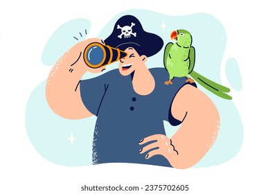 Little boy in pirate hat looks through spyglass and holds parrot on shoulder, dreaming of going on sea voyage. Schoolboy wants to be pirate or sailor and sail ocean on ship, leading team of sailors