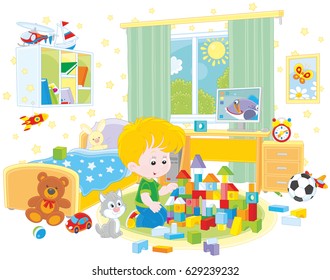 Little boy playing with bricks in his room