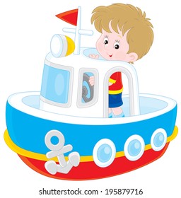 Little boy playing on board of a big toy ship