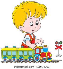 Little boy playing with a small toy train