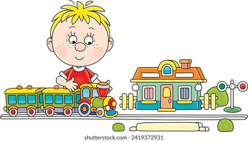 Little boy playing with a toy railway train and a station in his playroom, vector cartoon illustration on a white background