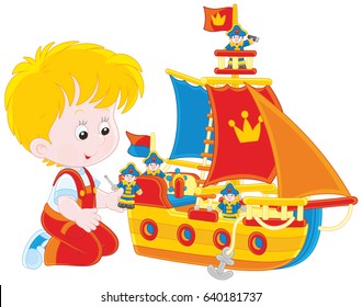 Little boy playing a toy sailing ship