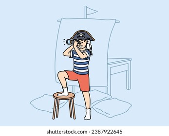 Little boy plays pirate holding spyglass and standing near ship mast made of sheet and imagining long sea voyage. Child pirate with parrot on shoulder performs enthusiastically in children theatre