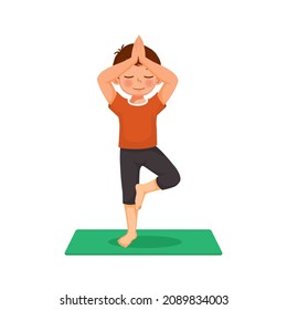 Little boy practicing yoga pose on a green mat indoor at home