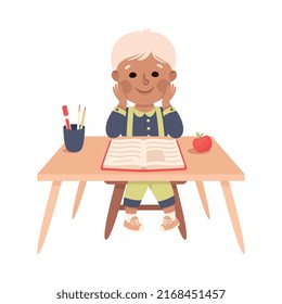 Little Boy Pupil Sitting at Table with Book Engaged in Elementary Education Vector Illustration