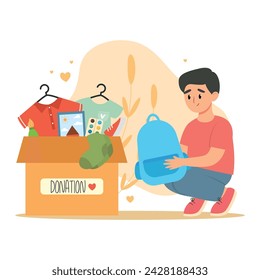 Little boy put backpack to cardboard donating box for charity. Clothes donation concept