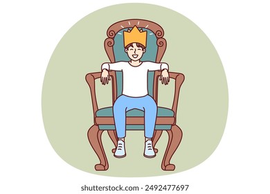 Little boy sits on throne with crown on head dreaming of growing up to be prince or king. Teenager boy in golden crown made of paper laughs with eyes closed and imagining monarchy.