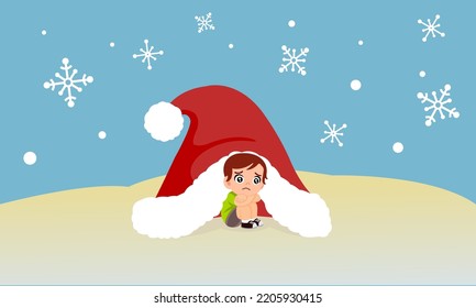 Little boy sitting alone in a big Santa Claus hat shielding the cold from the snow.Loneliness on Christmas New Year. Waiting for presents from Santa Claus.