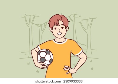 Little boy with soccer ball enjoys outdoor recreation and with smile looks at screen. Boy pupil elementary school, dreams of becoming professional football player and training in park to play soccer