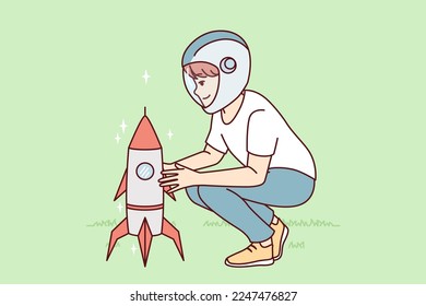 Little boy squatting near toy rocket representing launching spaceship to another planet. Child plays as astronaut, wanting to work in space industry and launch intergalactic ships. Flat vector design 