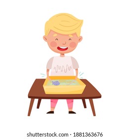 Little Boy Standing at Table and Splashing in Water Basin with Fish Vector Illustration