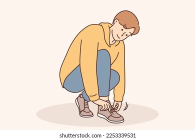 A little boy ties a shoelace on his shoe. Children's clothing for walking, training in tying shoes, tightening laces and tying knots, preparing children's shoes vector illustration