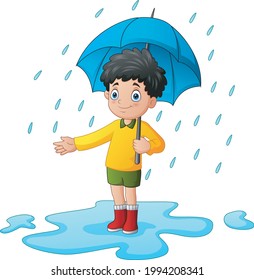 Little boy using umbrella under the rain