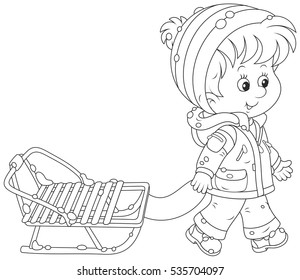 Little boy walking with his sled