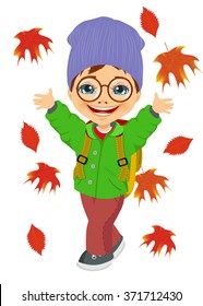 little boy wearing knitted hat playing with autumn leaves