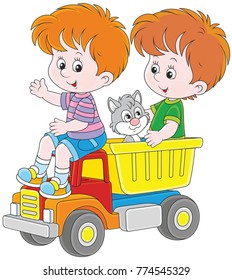 Little boys playing with a big toy truck and a small kitten