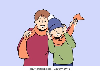 Little boys in winter hats and scarves rejoicing at onset of winter and preparing for walk in park. Boys brothers or friends having fun enjoying communication and coming of december holidays