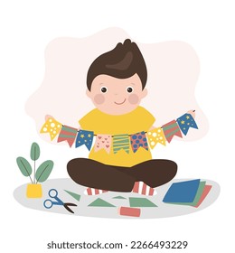 Little caucasian boy cuts and glues handmade crafts. Smart child made flags to decorate room or christmas tree. Education, creativity and art. Cheerful, creative child with paper and scissors. vector
