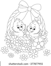 Little chickens in an Easter basket decorated with a bow and flowers