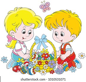 Little children with a decorated Easter basket of colorfully painted eggs and flowers