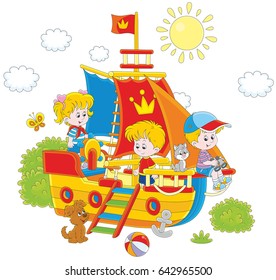 Little children playing on a toy sailing ship at a playground in a park