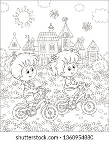 Little children riding bicycles near a cute small town on a sunny summer day, black and white vector illustration in a cartoon style for a coloring book